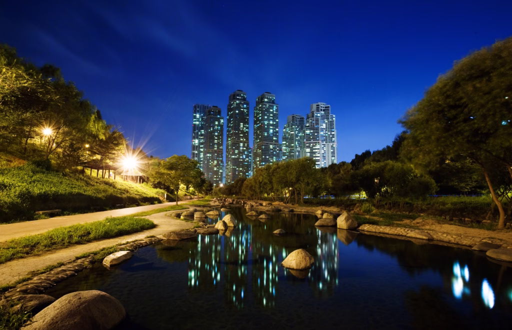Een serene avondfoto van de Cheonggyecheon Stream in Seoul, Zuid-Korea, met sfeervolle verlichting en moderne architectuur op de achtergrond.