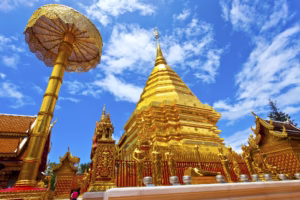Wat Phra That Doi Suthep, een gouden chedi omringd door kleurrijke gebedsvlaggen, met uitzicht op Chiang Mai vanaf een bergtop.
