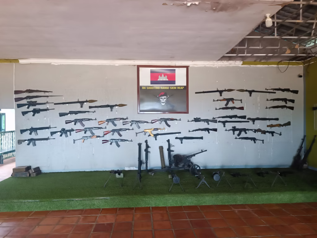 Muur met diverse vuurwapens – een indrukwekkende collectie geweren, pistolen en machinegeweren op een schietbaan in Siem Reap.